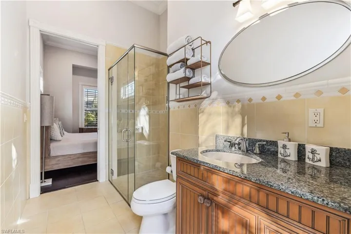 Bathroom with tile patterned flooring, vanity, tile walls, and toilet