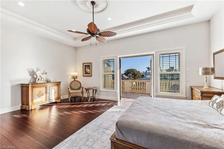 Primary Bedroom with a seating area, tray ceiling, ceiling and doors to your private balcony