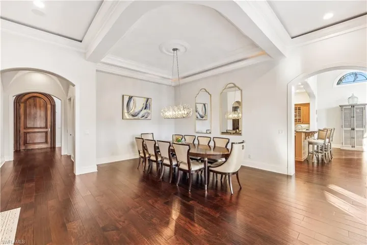 Dining room featuring a chandelier, dark hardwood / wood-style flooring, and crown molding