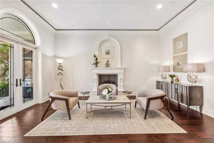 Elegant room with fire place, french doors, hardwood / wood-style flooring, and ornamental molding