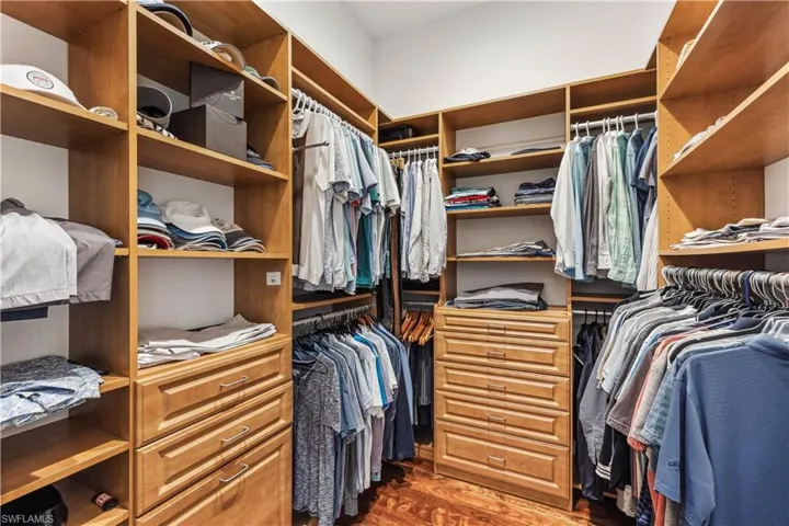 Spacious walk-in closet featuring dark hardwood / wood-style flooring
