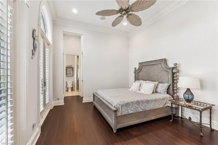 3rd Guest bedroom with ceiling fan, ensuite bathroom, dark wood-type flooring, and ornamental molding