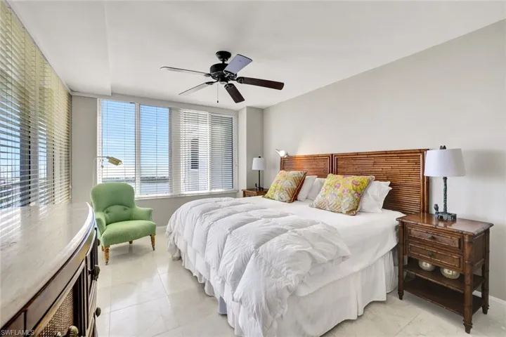 Bedroom with baseboards, light tile patterned flooring, and ceiling fan