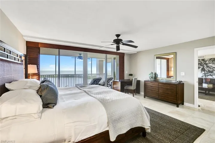 Bedroom with baseboards, a water view, a ceiling fan, access to exterior, and light tile patterned flooring