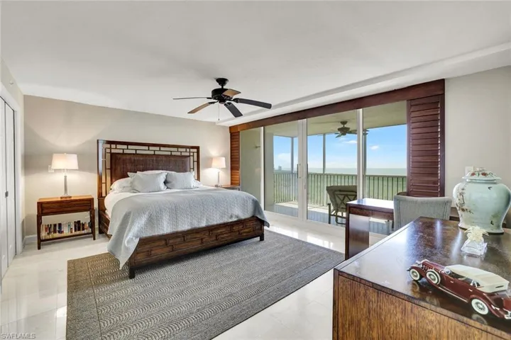 Bedroom with a water view, access to outside, and a ceiling fan