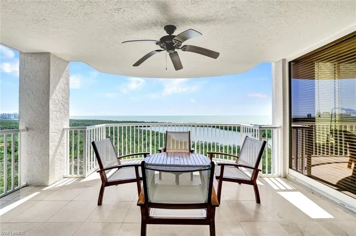 Balcony featuring a ceiling fan and a water view