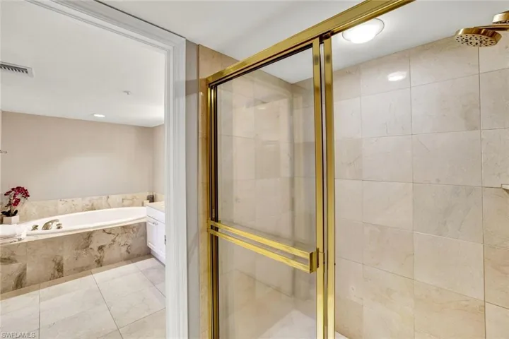 Bathroom with a shower stall, visible vents, and a bath