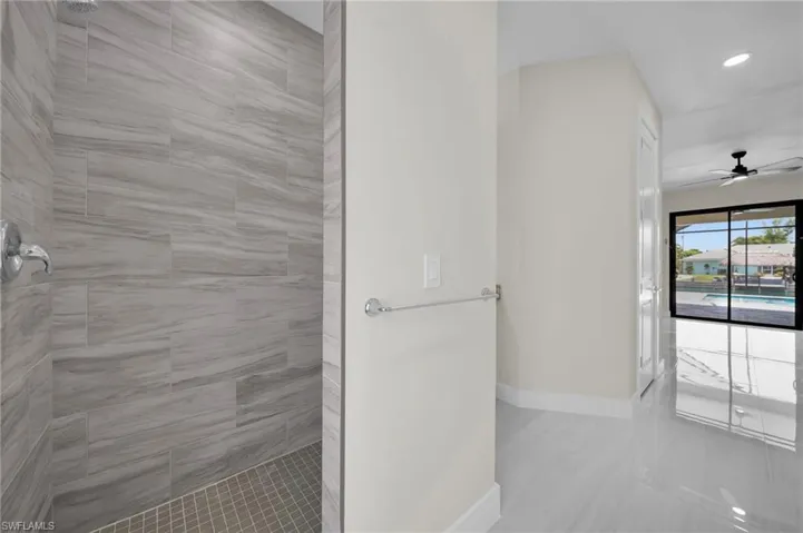 Full bathroom with a tile shower, ceiling fan, and recessed lighting