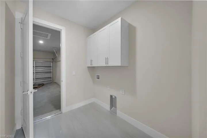 Laundry area featuring hookup for a washing machine, cabinet space, attic access, and hookup for an electric dryer