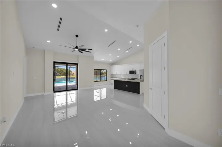 Unfurnished living room featuring vaulted ceiling, ceiling fan, recessed lighting, and light tile patterned floors