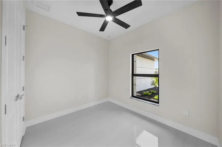 Spare room with ceiling fan and baseboards