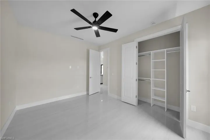 Unfurnished bedroom featuring a ceiling fan and a closet