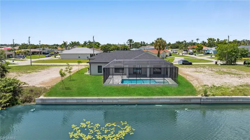 Rear view of property with a residential view, a yard, an outdoor pool, and glass enclosure