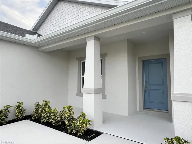 Doorway to property with a porch and stucco siding