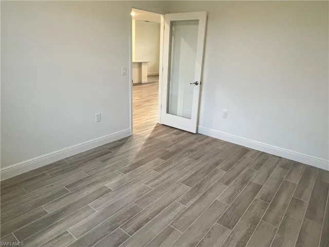 Spare room featuring wood finish floors and baseboards