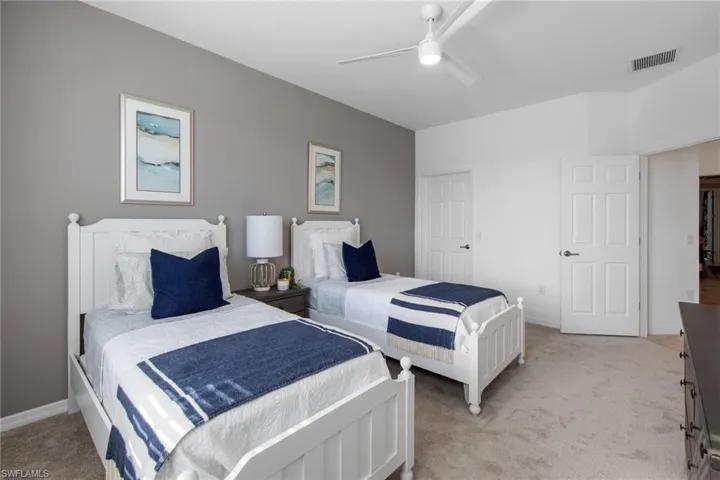 Bedroom with visible vents, ceiling fan, light carpet, and baseboards