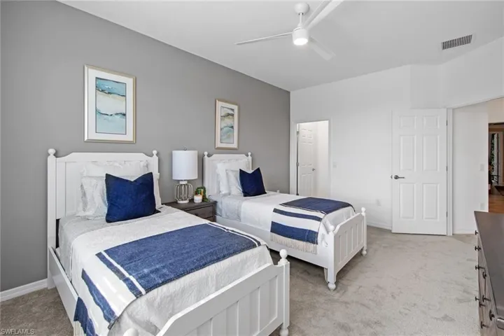 Bedroom featuring light colored carpet, baseboards, a ceiling fan, and visible vents