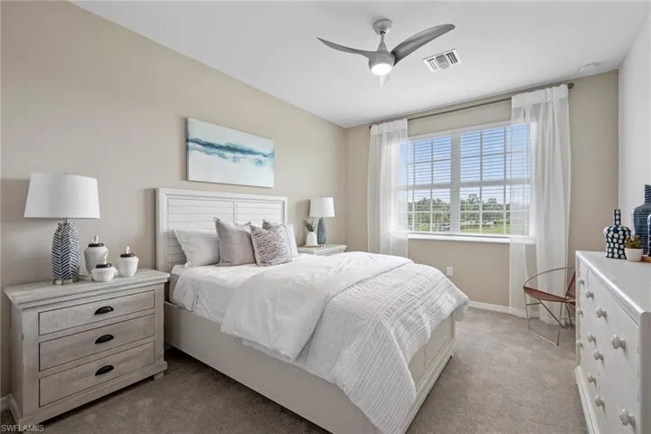 Carpeted bedroom featuring visible vents, baseboards, and a ceiling fan