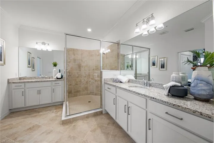 Full bath with a shower stall, a sink, and crown molding