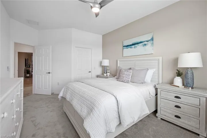 Bedroom featuring a closet, a ceiling fan, light colored carpet, and visible vents