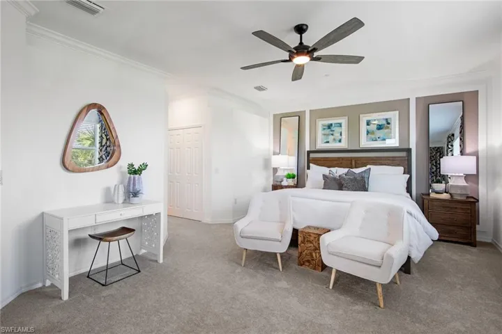 Carpeted bedroom with visible vents, baseboards, crown molding, and a ceiling fan
