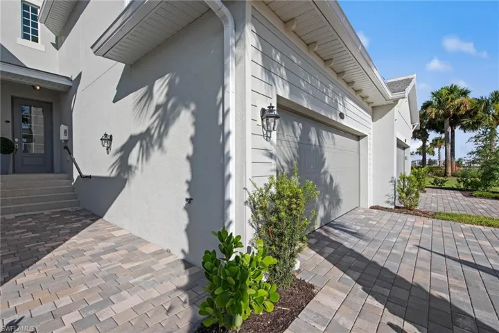 View of side of home with an attached garage and stucco siding