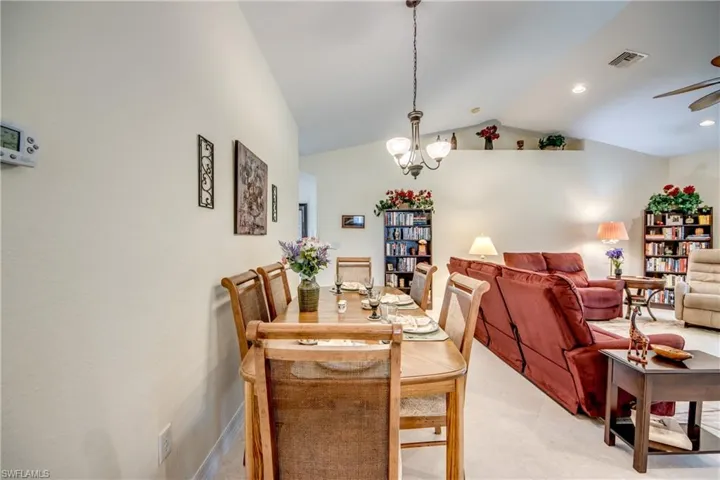 Dining room with lofted ceiling, ceiling fan, and a chandelier