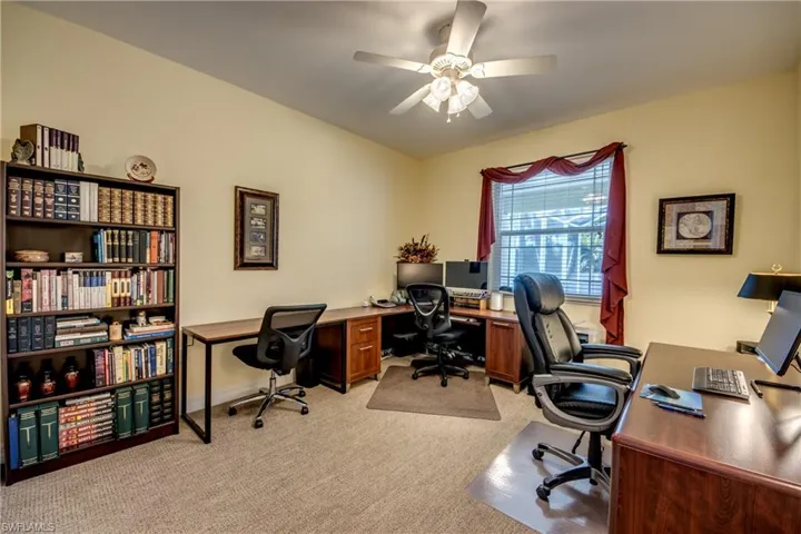 Office area featuring light colored carpet and ceiling fan
