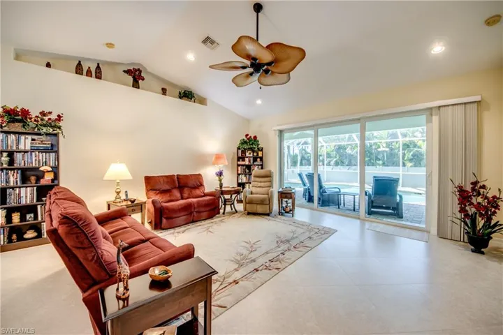 Living area with a ceiling fan, lofted ceiling, and recessed lighting