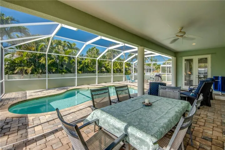 View of patio with ceiling fan, a lanai, and outdoor dining area