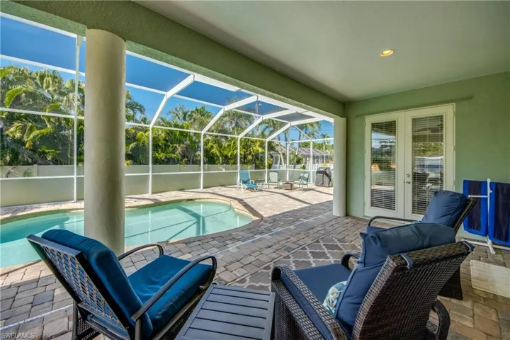 View of swimming pool featuring a patio area and a lanai
