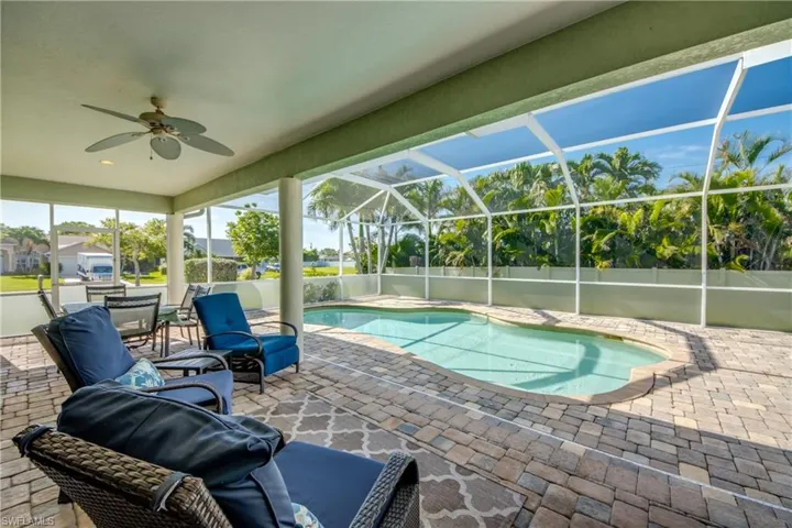View of swimming pool with a patio area, ceiling fan, and a lanai