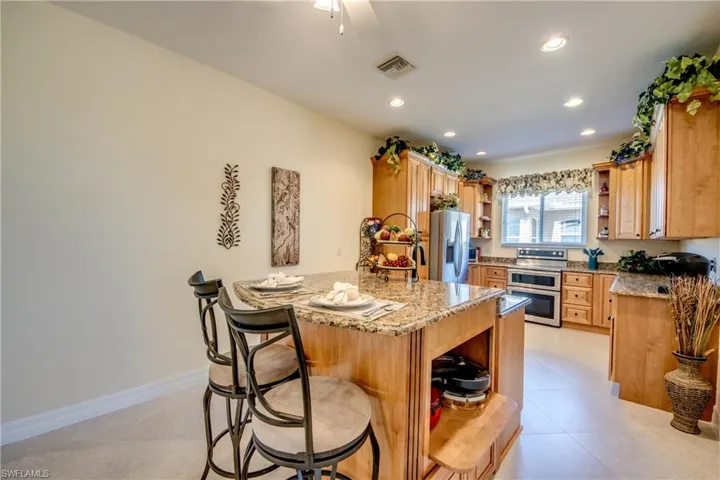 Kitchen with open shelves, stainless steel appliances, a peninsula, a kitchen breakfast bar, and recessed lighting