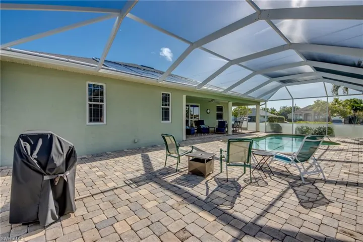 View of patio / terrace with a ceiling fan, area for grilling, an outdoor pool, and glass enclosure