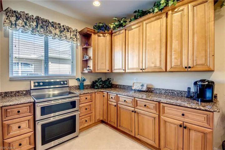 Kitchen featuring range with two ovens, stone countertops, recessed lighting, and open shelves