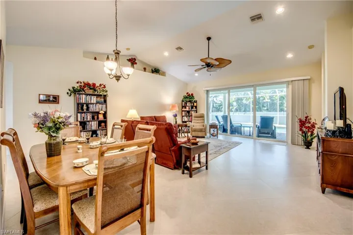 Dining room with ceiling fan, lofted ceiling, a chandelier, and recessed lighting