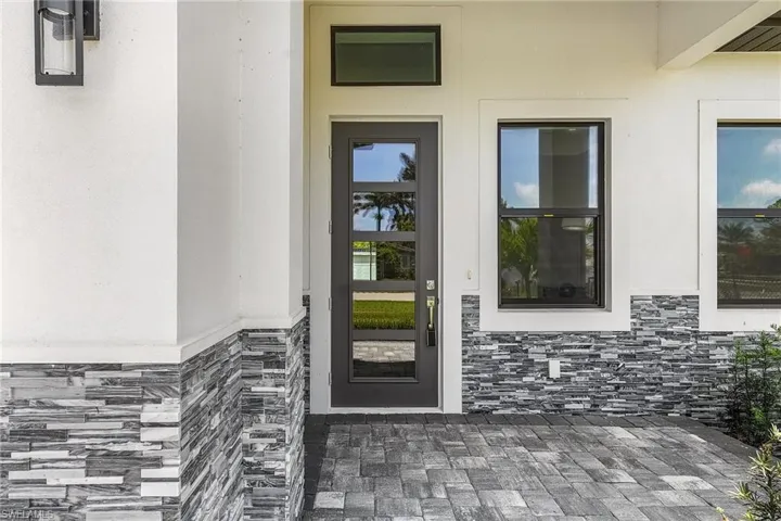Entrance to property with stone siding and stucco siding