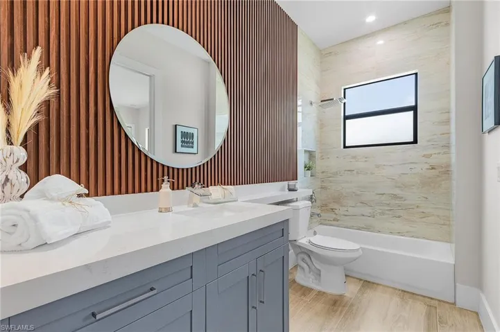 Bathroom featuring vanity, toilet, bathtub / shower combination, and recessed lighting
