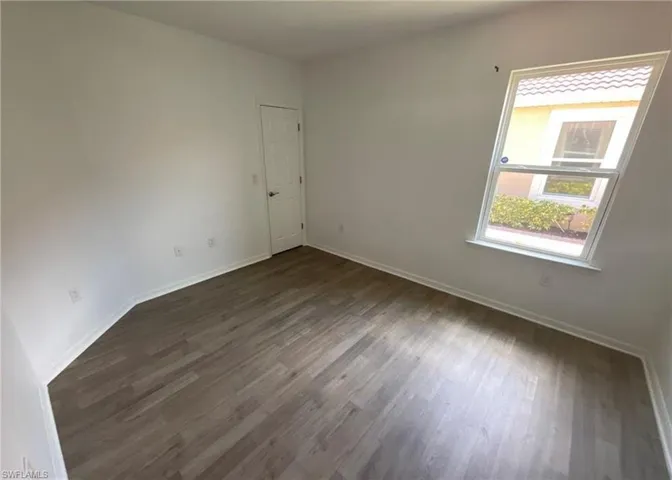 This room features light-colored walls, a window providing natural light, and wood-style flooring