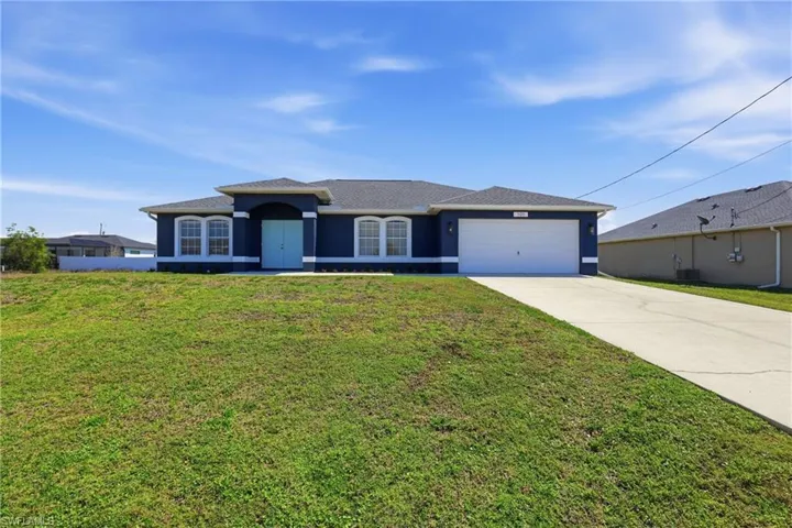 View of front of home featuring a front lawn, concrete driveway, an attached garage, and stucco siding
