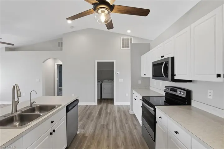 Kitchen featuring stainless steel appliances, light countertops, a ceiling fan, white cabinets, and recessed lighting