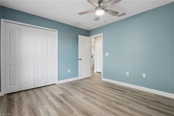 Unfurnished bedroom with ceiling fan, light wood finished floors, and a closet