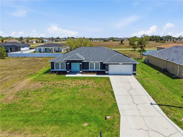 Ranch-style house with roof with shingles, a front lawn, driveway, a residential view, and a garage