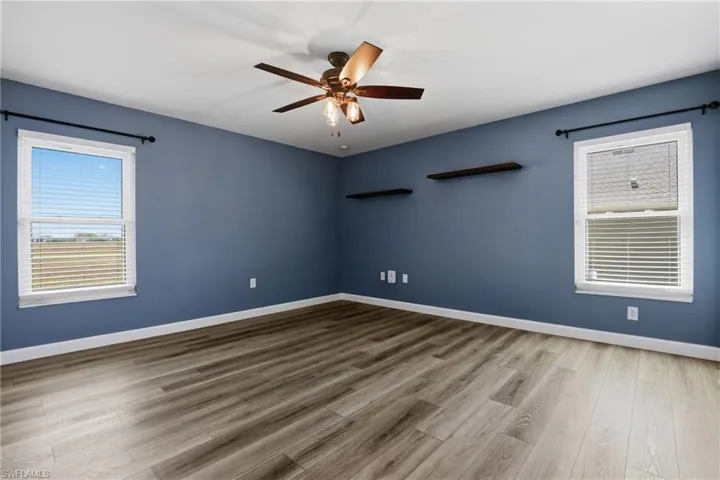Spare room with light wood finished floors and a ceiling fan