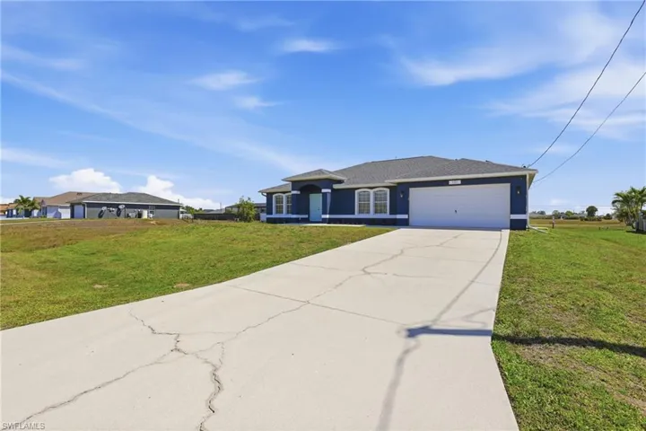 Ranch-style house with a front yard, driveway, an attached garage, and roof with shingles