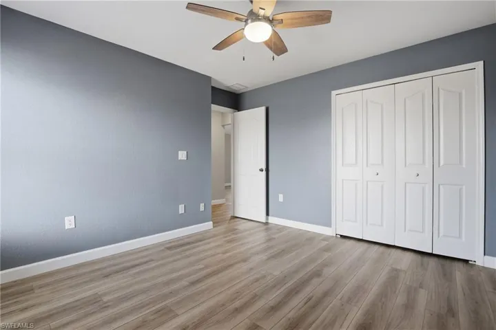 Unfurnished bedroom featuring a ceiling fan, light wood-type flooring, and a closet