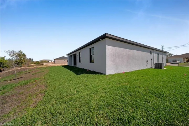 View of home's exterior with stucco siding and a lawn