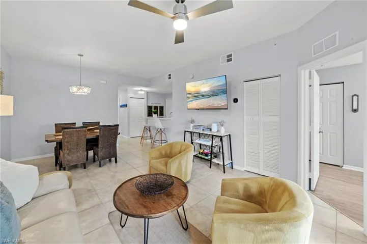Open concept living space featuring tile flooring, a ceiling fan with integrated lighting, and light-colored walls