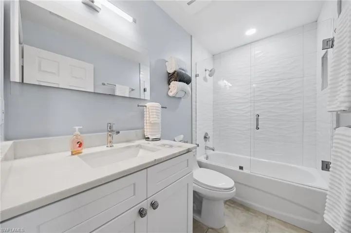 The bathroom features a vanity with a white countertop and cabinet storage