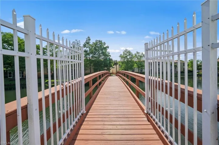 The property features a wooden bridge with white railings, spanning over a body of water